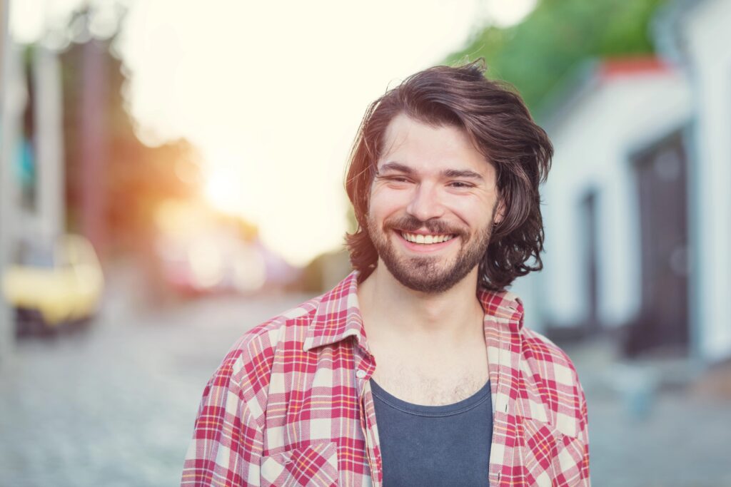 Smiling young man with longer hair, hockey flow haircut